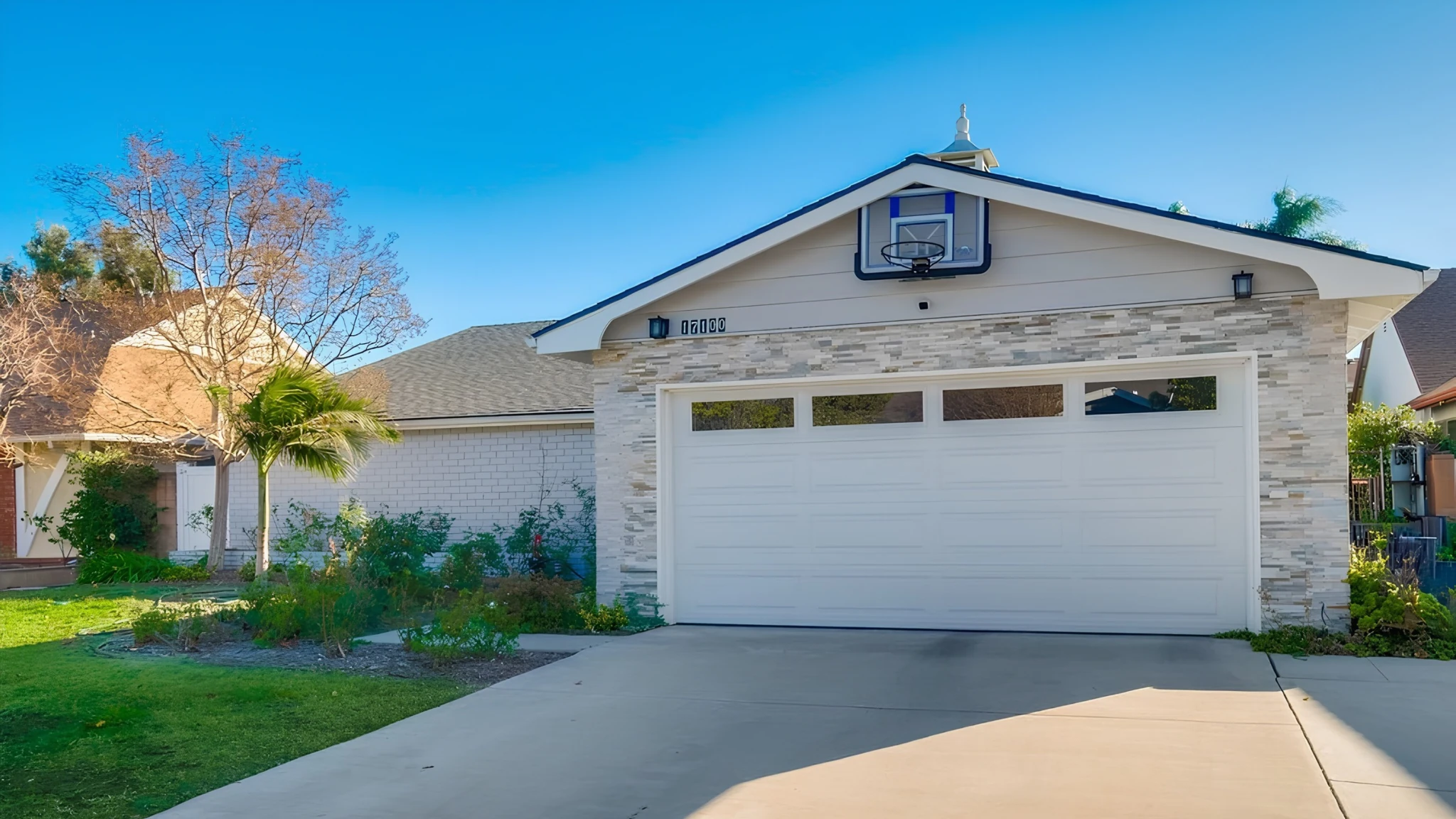 Front of 17100 Minnehaha Street in Granada Hills, with garage, basketball hoop and landscaped lawn
